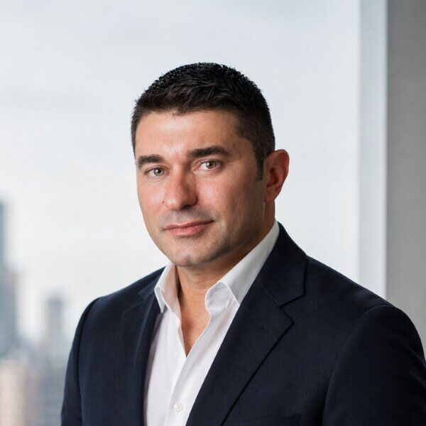 Professional headshot of Alex Haidar, smiling and looking toward the camera against a neutral background.